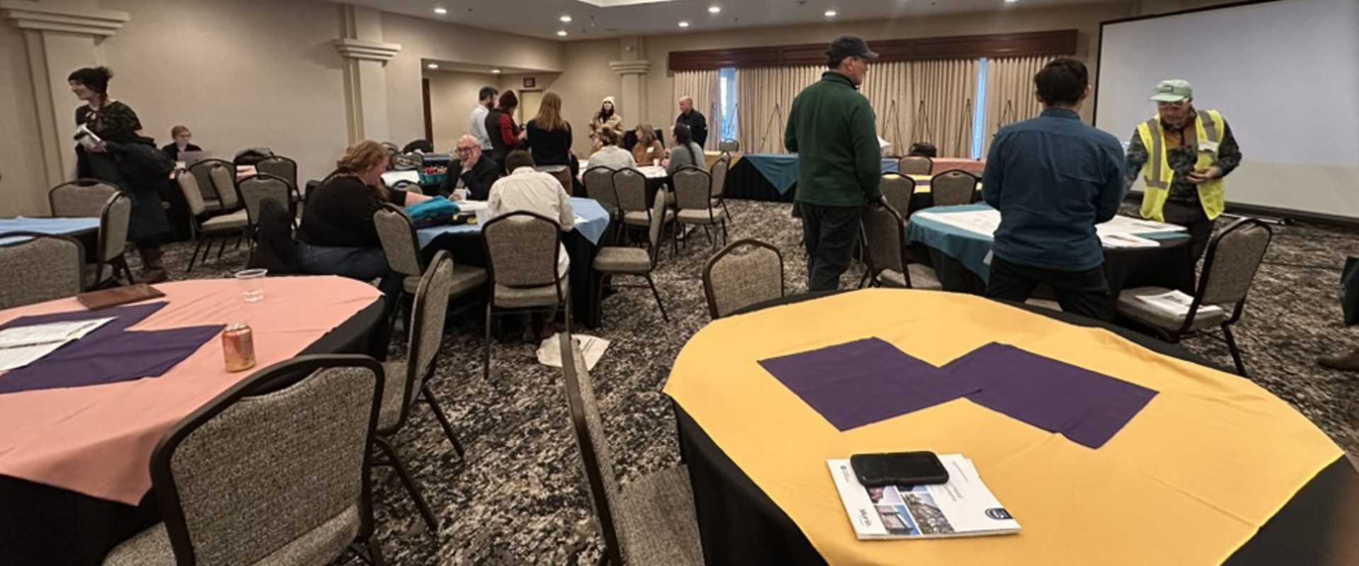 Event gathering space, showcasing collaborative discussions around vibrant tables in a dynamic workshop.